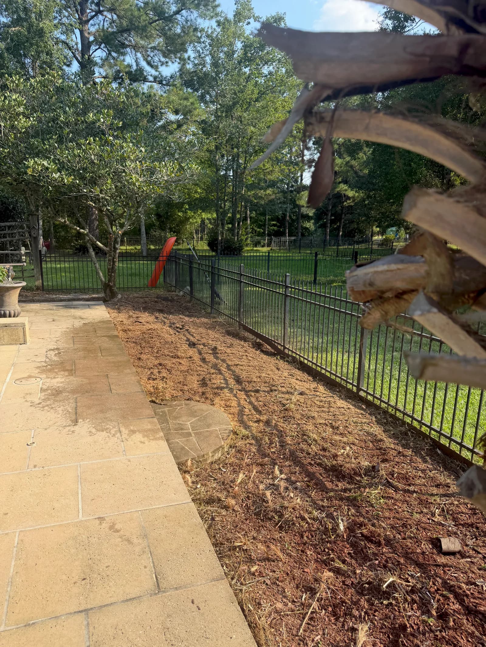 Same narrow strip between pool deck and fence with the stump fully ground out and area cleared
